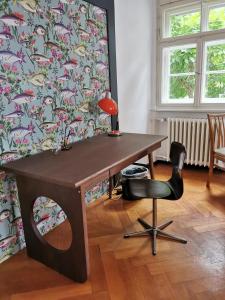 einen Schreibtisch und einen Stuhl in einem Zimmer mit einer Wand in der Unterkunft Gundis Gästezimmer in Bamberg