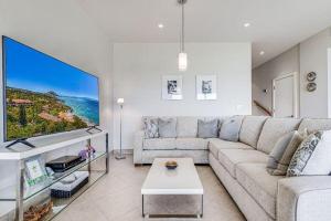 a living room with a couch and a large tv at MAKENA SURF #F-102 condo in Wailea