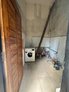 a laundry room with a washing machine and a door at Exotic Backpackers in Banyuwedang