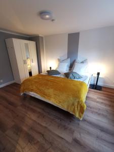 マイニンゲンにあるApartment Violaのベッドルーム1室(大型ベッド1台、黄色い毛布付)