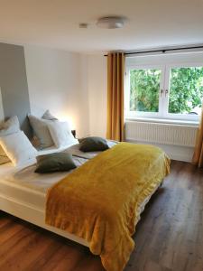 a bedroom with a large bed with a yellow blanket at Apartment Viola in Meiningen