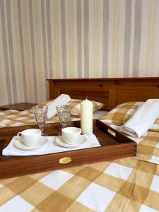 stół z dwoma kubkami i świecą na łóżku w obiekcie Willa Karolinka w Łebie
