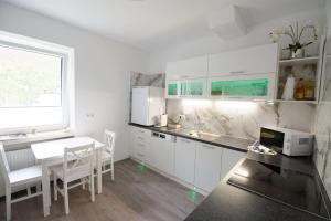 a kitchen with white cabinets and a table and chairs at Apartment Sunshine in Waidhofen an der Thaya