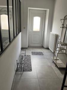 pasillo con puerta y suelo de baldosa en Maison villageoise, en Anhée