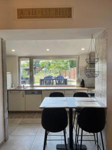 cocina con mesa, sillas y ventana en Maison villageoise, en Anhée