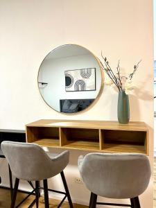 a mirror sitting on top of a desk with two chairs at Moderne Erdgeschosswohnung in Augsburg