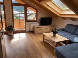 ein Wohnzimmer mit einem Sofa und einem TV in der Unterkunft Ferienwohnung Ferchensee in Mittenwald