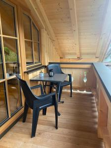 einen kleinen Tisch und Stühle auf der Veranda einer Hütte in der Unterkunft Ferienwohnung Ferchensee in Mittenwald