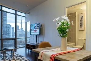 a room with a table with a vase of flowers on it at Lovely 1 bed in Central Toronto in Toronto