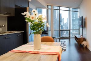 a vase of flowers sitting on top of a table at Lovely 1 bed in Central Toronto in Toronto