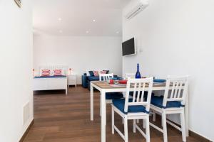 comedor y sala de estar con mesa y sillas en Due Golfi Apartment, en SantʼAgata sui Due Golfi
