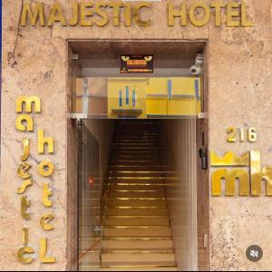 uma escada que leva a um hotel de massagens com uma placa em Majestic Hotel em Campina Grande