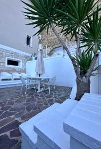 a table and chairs in a courtyard with a tree at NUMERONOVE Sirolo in Sirolo