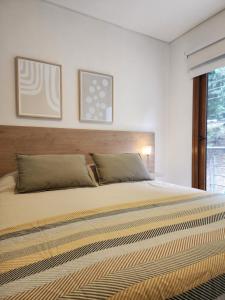 1 dormitorio con 1 cama grande y 2 almohadas en R&R Vibes en Villa La Angostura