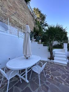 a table and chairs with an umbrella on a patio at NUMERONOVE Sirolo in Sirolo