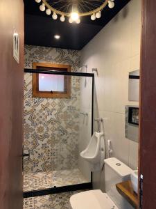 a bathroom with a toilet and a sink and a urinal at Pousada Lazúli in Macaé