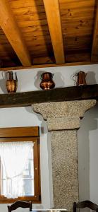 a stone fireplace in a room with a wooden ceiling at Hostal Plaza in Segovia