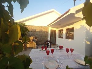 a table with red wine glasses and plates on it at Gerês e Cabreira - Romoa Vintage Guest House in Vieira do Minho