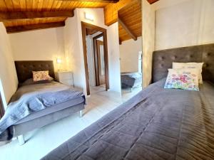 1 Schlafzimmer mit 2 Betten in einem Zimmer mit Holzdecken in der Unterkunft Immobillario - Villa Viva Como in Domaso