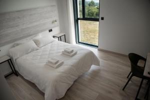 sypialnia z białym łóżkiem i 2 ręcznikami w obiekcie Hotel Chips Fene w mieście Fene