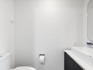 Baño blanco con aseo y lavamanos en SPECIAL OFFER - Miami 2BR - 1 & Half Bath - Steps to Kaseya Center, en Miami