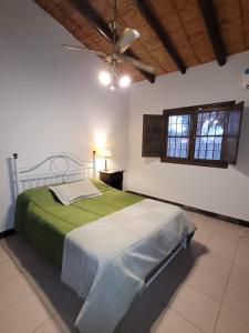 1 dormitorio con 1 cama y ventilador de techo en Terrales Zonda en San Juan