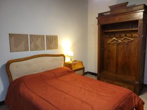1 dormitorio con 1 cama y armario de madera en Terrales Zonda en San Juan