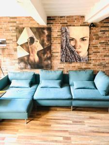 a living room with a blue couch against a brick wall at Casa Torre San Lorenzo in Pisa +34 photos