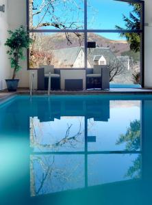 - une piscine avec vue sur une maison dans l'établissement Hotel Le Panorama, à Le Mont-Dore