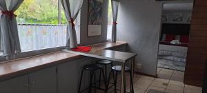 a kitchen with a counter and stools in a bedroom at Our Place - Family - 5 bed unit in Bloemfontein +6 photos