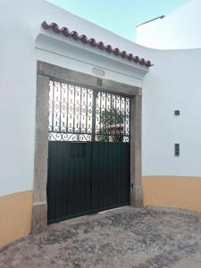 Una puerta de garaje negra con una puerta de metal en Casa Pátio do Megué, en Évora