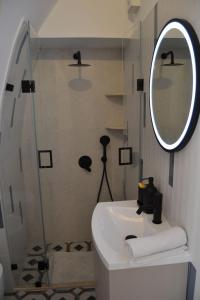 a bathroom with a sink and a mirror and a shower at Casa Zizì in Locorotondo