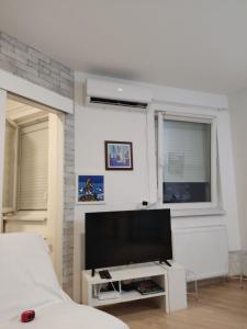 a bedroom with a flat screen tv and a bed at Apartman Regina in Užice
