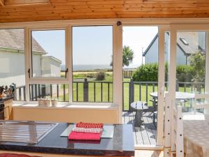 un porche cubierto con ventanas y mesa en Sandeel Bay, en Fethard-on-Sea