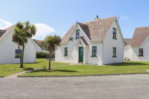 una casa blanca con palmeras delante en Sandeel Bay, en Fethard-on-Sea