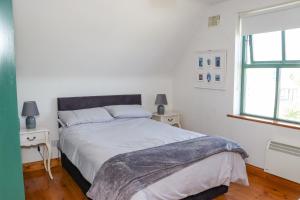 1 dormitorio con 1 cama, 2 mesas y una ventana en Sandeel Bay, en Fethard-on-Sea