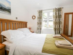 格蘭奇奧沃桑茨的住宿－Pippin Lodge，卧室设有一张白色大床和一扇窗户。