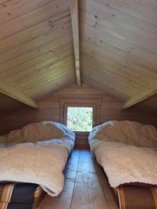 a room with two beds in a log cabin at Jootme-Andruse Puhkemaja in Kuressaare