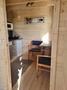 a small kitchen with a table and chairs in a cabin at Jootme-Andruse Puhkemaja in Kuressaare