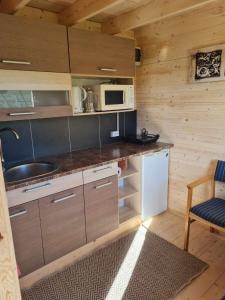 a kitchen with a counter with a sink and a microwave at Jootme-Andruse Puhkemaja in Kuressaare +7 photos