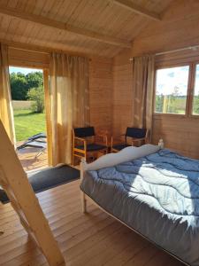 a bedroom in a log cabin with a bed and a table at Jootme-Andruse Puhkemaja in Kuressaare