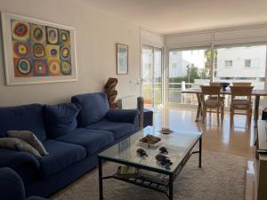 sala de estar con sofá azul y mesa de cristal en Blue Ocean en Platja  d'Aro