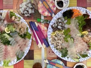 tre piatti di cibo su un tavolo di legno di My Summer Vacations - Vacation STAY 14738 a Kurashiki