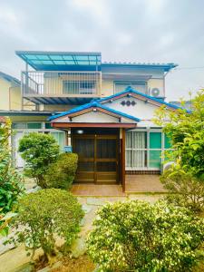 una casa con una puerta de madera delante de ella en My Summer Vacations - Vacation STAY 14738 en Kurashiki