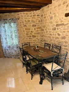 uma mesa e cadeiras num quarto com uma parede de pedra em maison Saint Berain sur Dheune em Saint-Berain-sur-Dheune