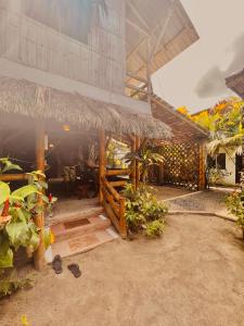 una cabaña con techo de paja y algunas plantas en Onda Hostel Mompiche, en Mompiche