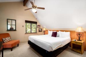 um quarto com uma cama grande e uma cadeira em Prescott Pines Inn em Prescott