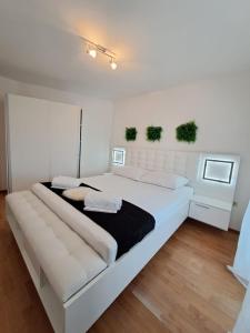 een witte slaapkamer met een groot wit bed bij Apartman Dawidh in Šibenik