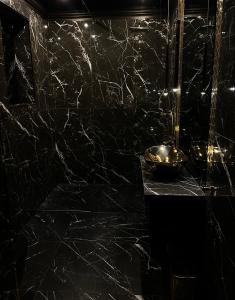 a black marble bathroom with two bowls on a counter at LuxuryApartments in Warsaw