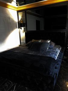 a bed in a dark room with a lamp at LuxuryApartments in Warsaw